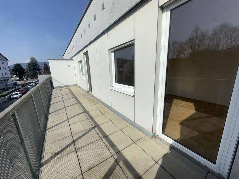 Langer Balkon mit Fliesenboden und Blick auf die Umgebung.