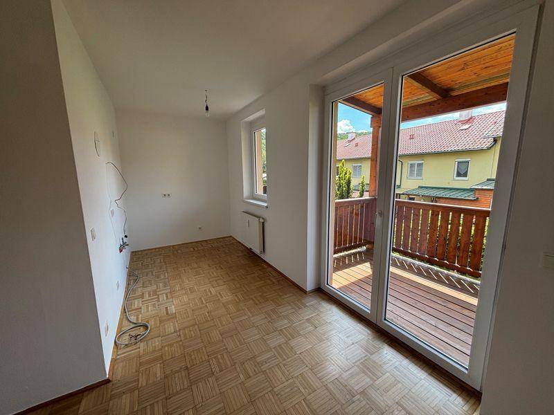 Leeres Zimmer mit Parkettboden und großem Balkonzugang, bereit zur individuellen Gestaltung.