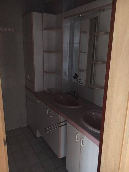Badezimmer mit Doppelwaschbecken, Spiegelschrank und Einbauschränken in hellem Design.