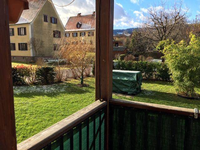 Blick vom Balkon auf den gepflegten Gartenbereich und die umliegende Wohngegend.