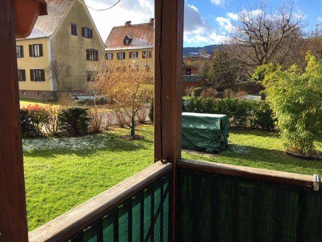Blick vom Balkon auf den gepflegten Gartenbereich und die umliegende Wohngegend.