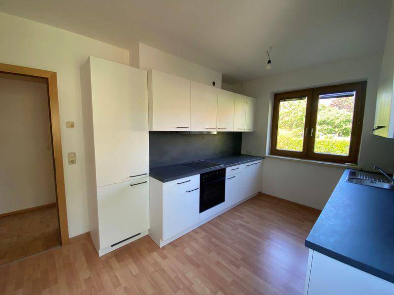 Moderne Einbauküche mit weißen Fronten, integriertem Backofen und viel Stauraum.