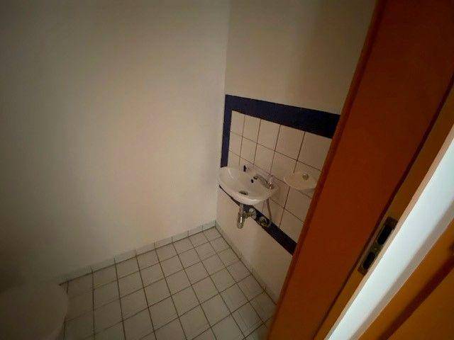 Kleines Badezimmer oder Gäste-WC mit Waschbecken und blauer Akzentfliesenreihe.
