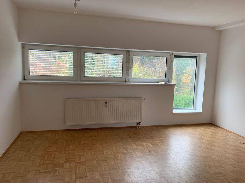 Geräumiges Zimmer mit Parkettboden, weißen Wänden und großen Fenstern für viel Tageslicht.