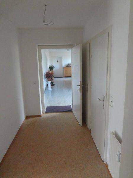 Langer Flur mit Laminatboden und Blick in einen weiteren Wohnbereich.
