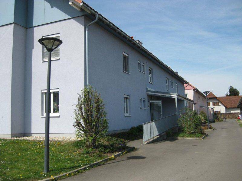 Seitenansicht des Gebäudes mit Zufahrtsrampe und Straßenlaterne.