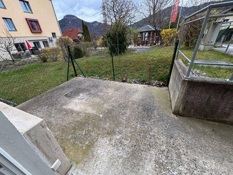 Gepflegter Gartenbereich mit Rasenfläche, Zaun und einem Pavillon im Hintergrund.