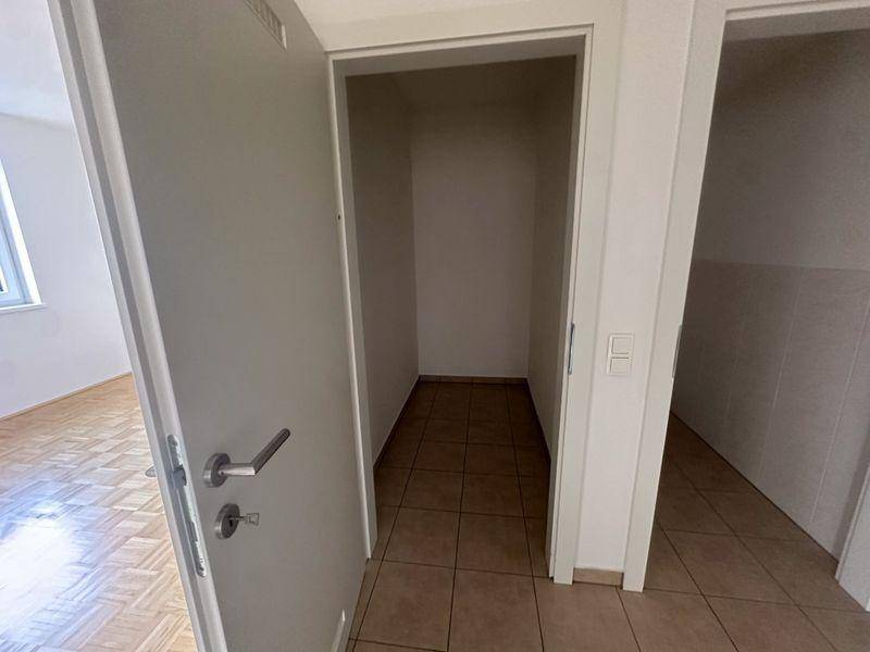 Eingangsbereich mit gefliestem Boden und einer praktischen Nische für Stauraum oder Garderobe.
