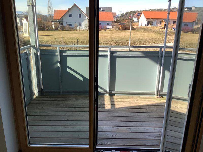 Balkon mit Holzboden und Metallgeländer, bietet einen weiten Blick auf die ländliche Umgebung.