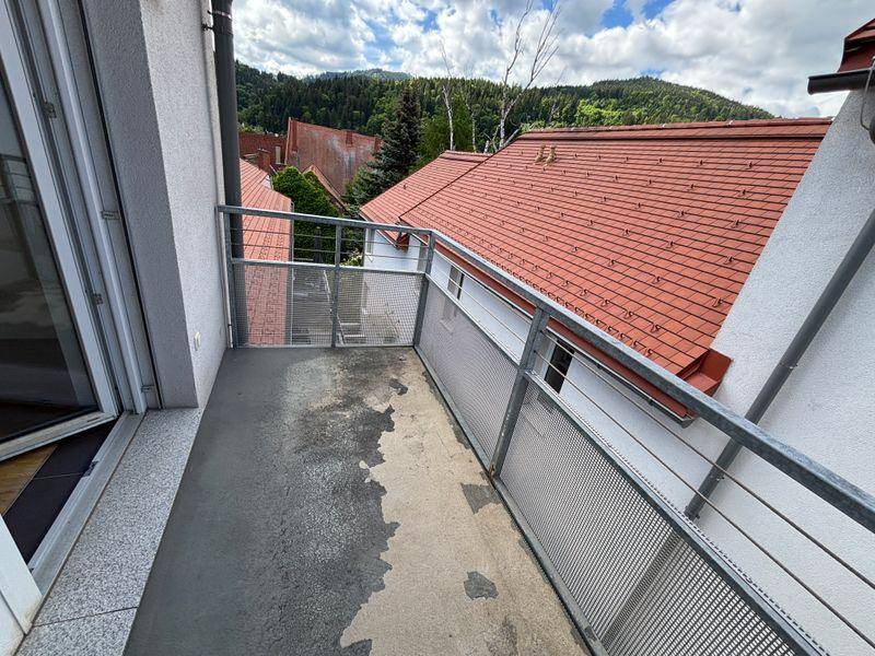 Balkon mit Metallgeländer und weitem Blick auf die umliegende grüne Berglandschaft.