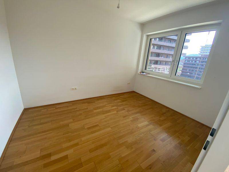 Ruhiges Schlafzimmer mit Parkettboden und Fenster, bietet einen angenehmen Rückzugsort.