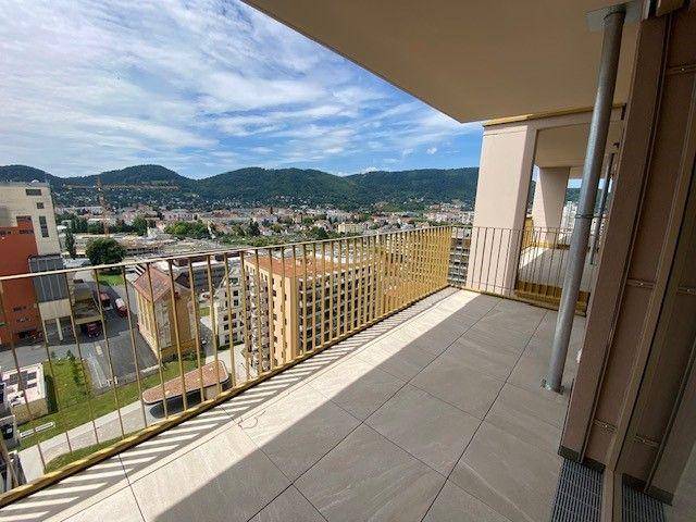 Geräumiger Balkon mit Fliesenboden und goldenem Geländer, bietet weiten Blick über die Stadt und Hügel.