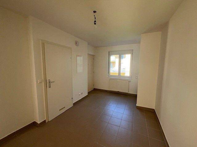 Raum mit Fliesenboden, Fenster und Heizkörper, vielseitig nutzbar.