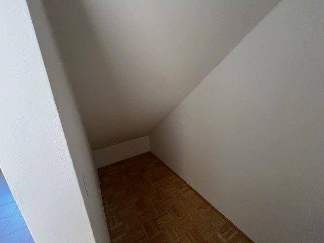 Praktischer Abstellraum mit Dachschräge und Parkettboden für zusätzlichen Stauraum.