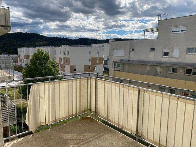 Geräumiger Balkon mit weitem Blick auf die Nachbarschaft und grüne Hügel.
