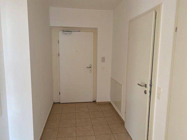 Eingangsbereich mit Fliesenboden und weißer Wohnungstür, bietet einen freundlichen Empfang.