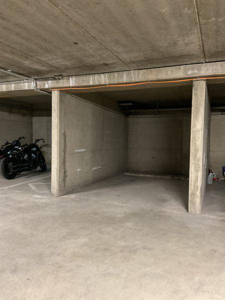 Tiefgarage mit Betonwänden und -boden, bietet Stellplätze für Fahrzeuge.