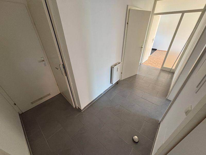 Heller Flur mit modernem Fliesenboden und Zugang zu verschiedenen Räumen.