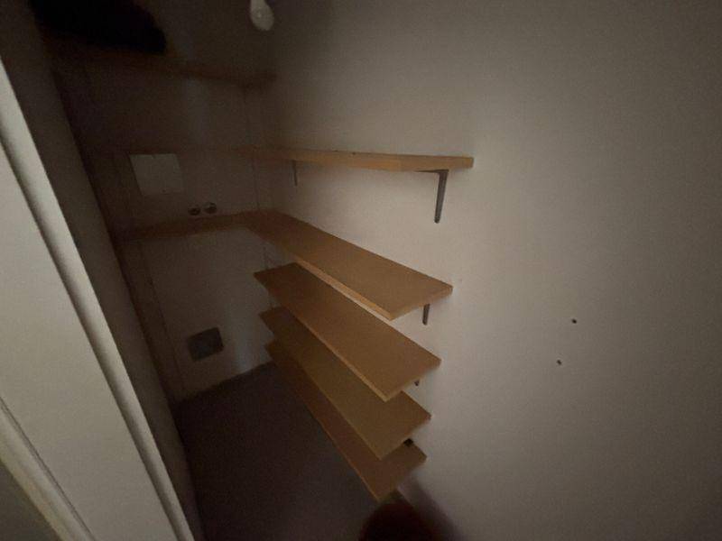 Praktischer Abstellraum mit mehreren Holzregalen für zusätzlichen Stauraum.