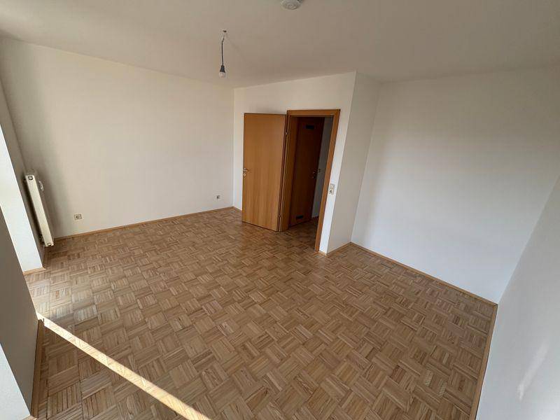Heller Wohnraum mit Parkettboden und Zugang zu weiteren Zimmern, vielseitig nutzbar.