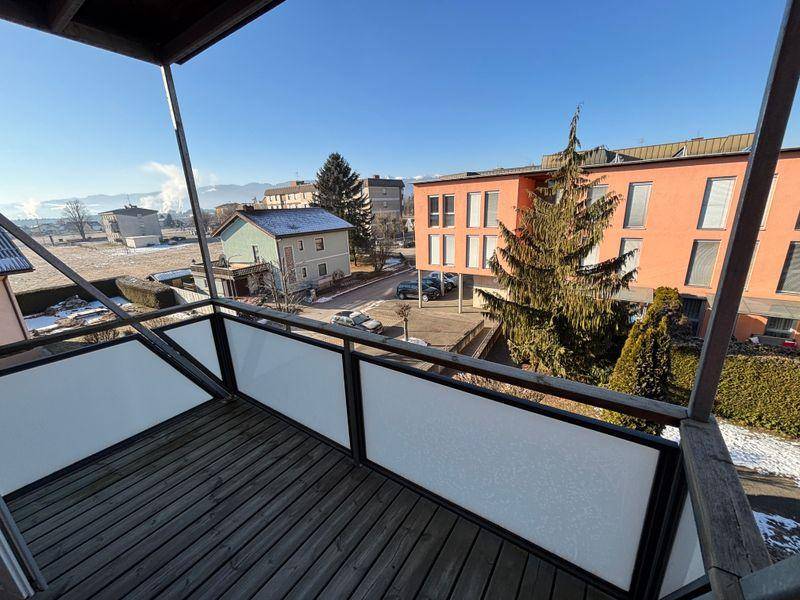 Balkon mit Holzboden und Blick auf die umliegende Wohngegend, perfekt für entspannte Stunden.