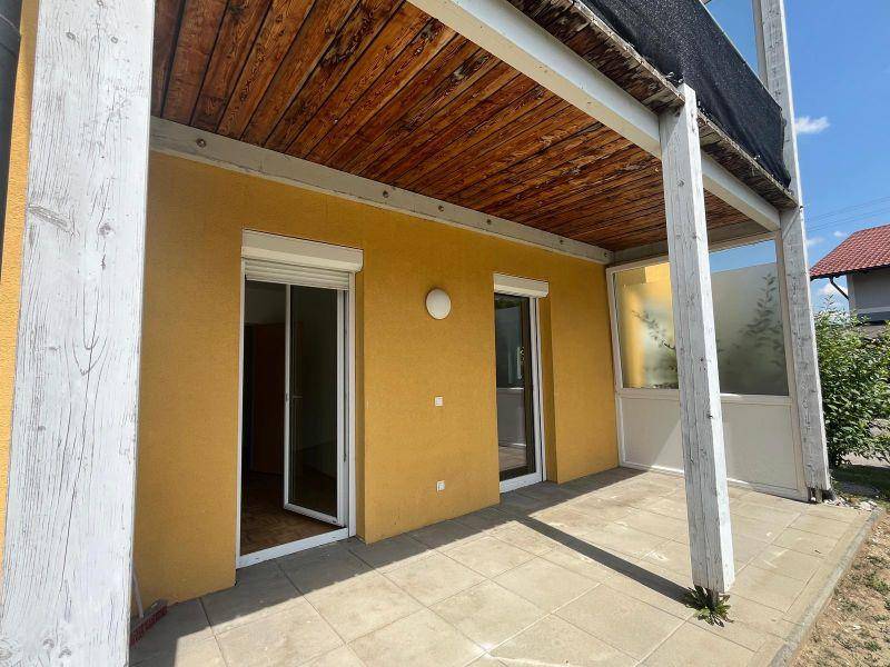 Geräumige überdachte Terrasse mit Holzdach und Fliesenboden, ideal für entspannte Stunden im Freien.