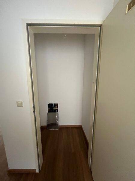 Leerer Abstellraum mit Holzboden und weißen Wänden, ideal für zusätzlichen Stauraum.