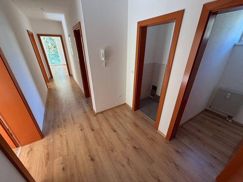 Heller Flur mit Laminatboden und mehreren Türen zu den Zimmern.