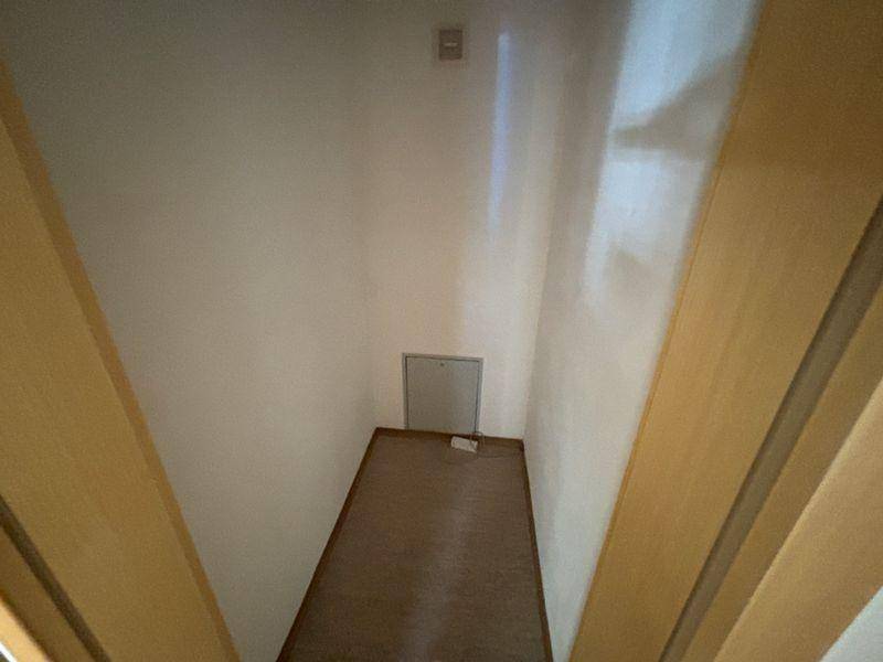Kleiner Abstellraum mit hellem Boden und Zugangsklappe.