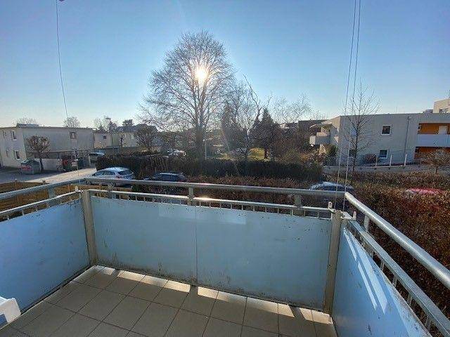 Sonniger Balkon mit Fliesenboden und weitem Blick über die Nachbarschaft.