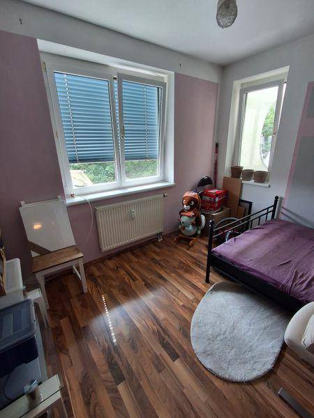 Kinderzimmer mit Holzboden, Einzelbett und Fenster mit Blick ins Grüne.