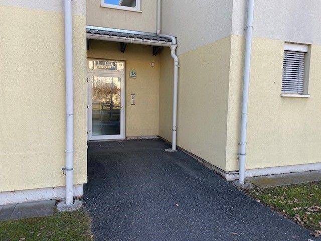 Eingangsbereich eines Wohnhauses mit Hausnummer 45 und gepflastertem Zugang.