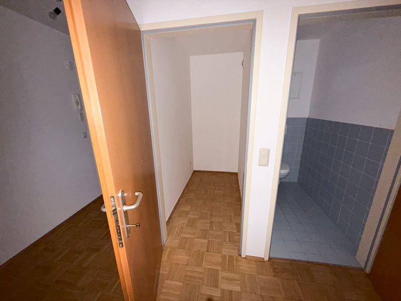 Flur mit Parkettboden und Zugang zu einem WC und einem weiteren Raum.
