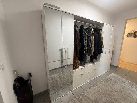 Geräumiger Flur mit großem Spiegelschrank und integrierter Garderobe für Mäntel und Schuhe.