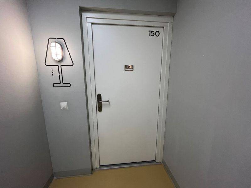 Eingangstür einer Wohnung mit der Nummer 150 in einem modernen Flur.