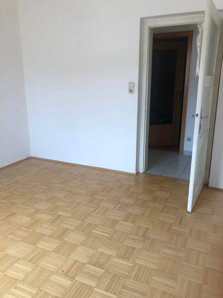 Geräumiges Zimmer mit Parkettboden und weiß gestrichenen Wänden, bereit zur Einrichtung.