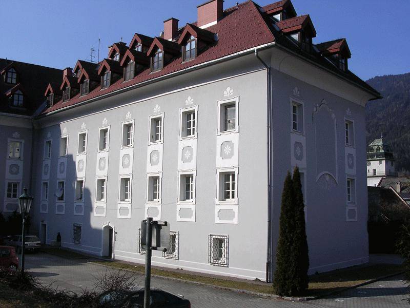 Seitenansicht des historischen Gebäudes mit detailreicher Fassadengestaltung und rotem Ziegeldach.