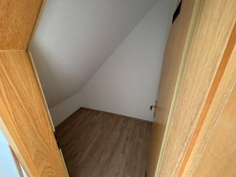 Kleiner Abstellraum mit Laminatboden und Dachschräge, ideal für zusätzlichen Stauraum.