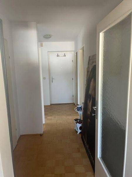 Heller Flur mit Laminatboden und Zugang zu verschiedenen Räumen der Wohnung.