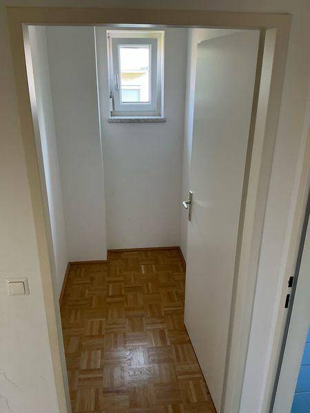 Kleiner, heller Raum mit Parkettboden und Fenster, ideal als Abstellraum oder kleines Büro.