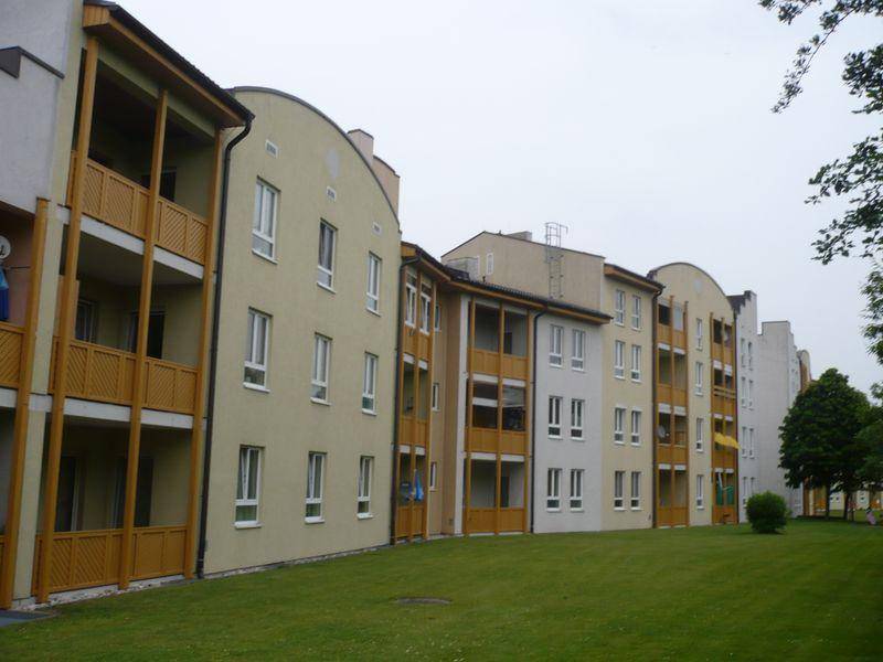 Mehrere Wohngebäude mit Balkonen und gepflegter Grünfläche in einer ruhigen Umgebung.