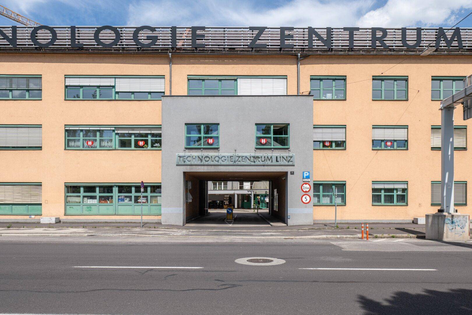 Fassade eines Technologiezentrums mit mehreren Fenstern und einem Durchgang.
