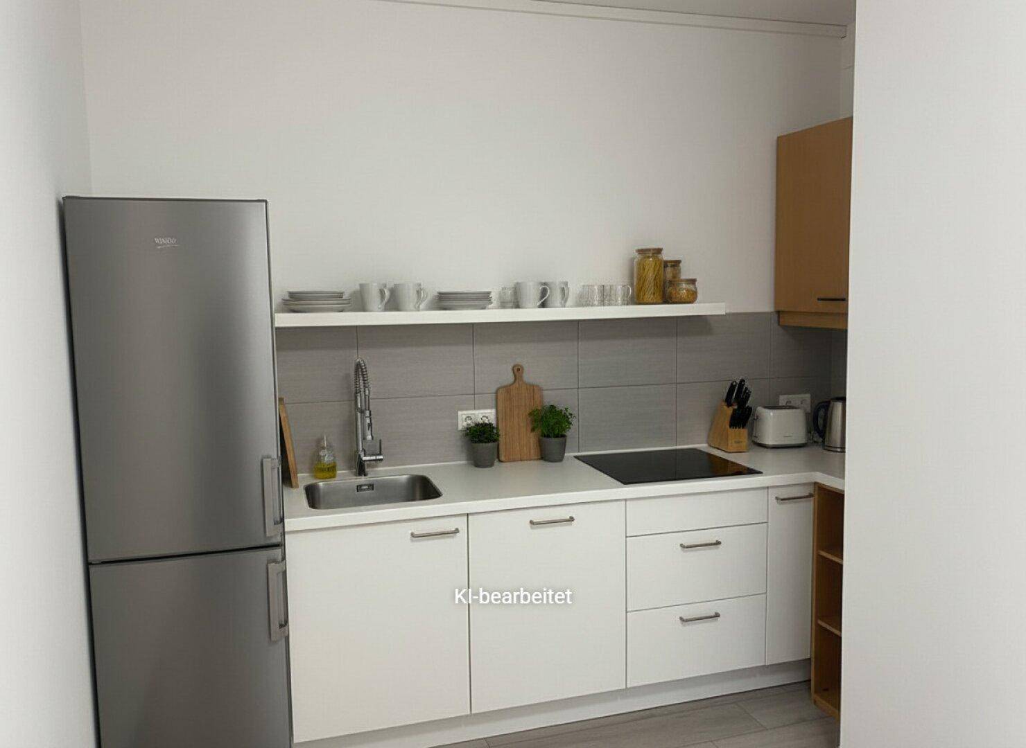 Funktionale Küchenzeile mit Kühlschrank, Spüle und Kochfeld, ideal für kleine Büros oder Apartments.