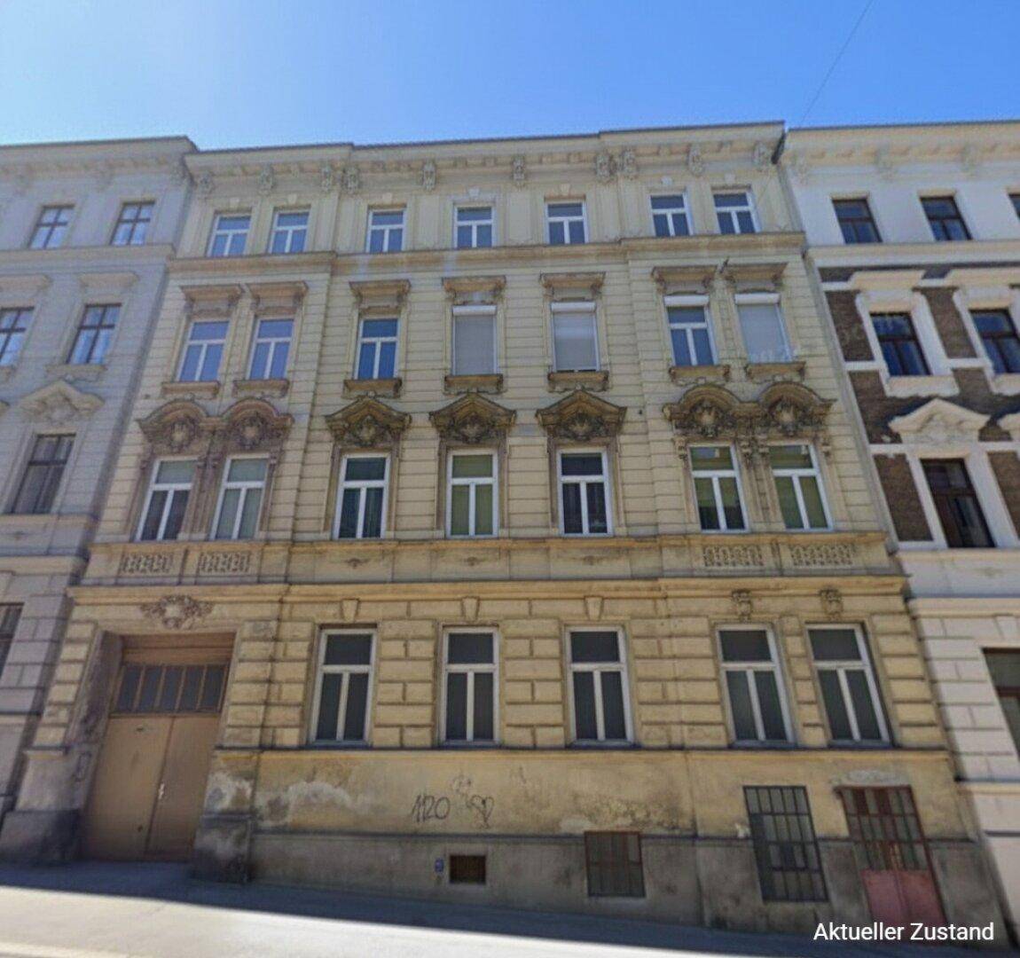 Aktueller Zustand der historischen Fassade eines Altbaus mit Stuckverzierungen und sichtbaren Gebrauchsspuren.