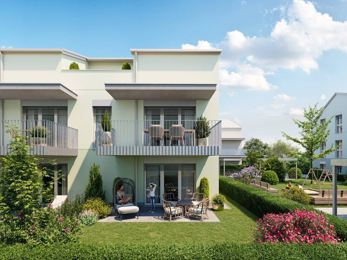 Nahaufnahme einer modernen Wohnfassade mit Balkonen, einer möblierten Terrasse und einem grünen Gartenbereich.