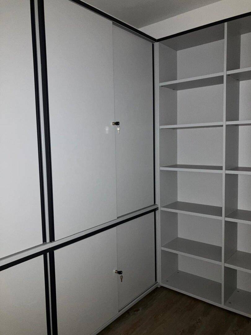 Moderne Einbauschränke und Regale in einem Büroraum für optimale Organisation.