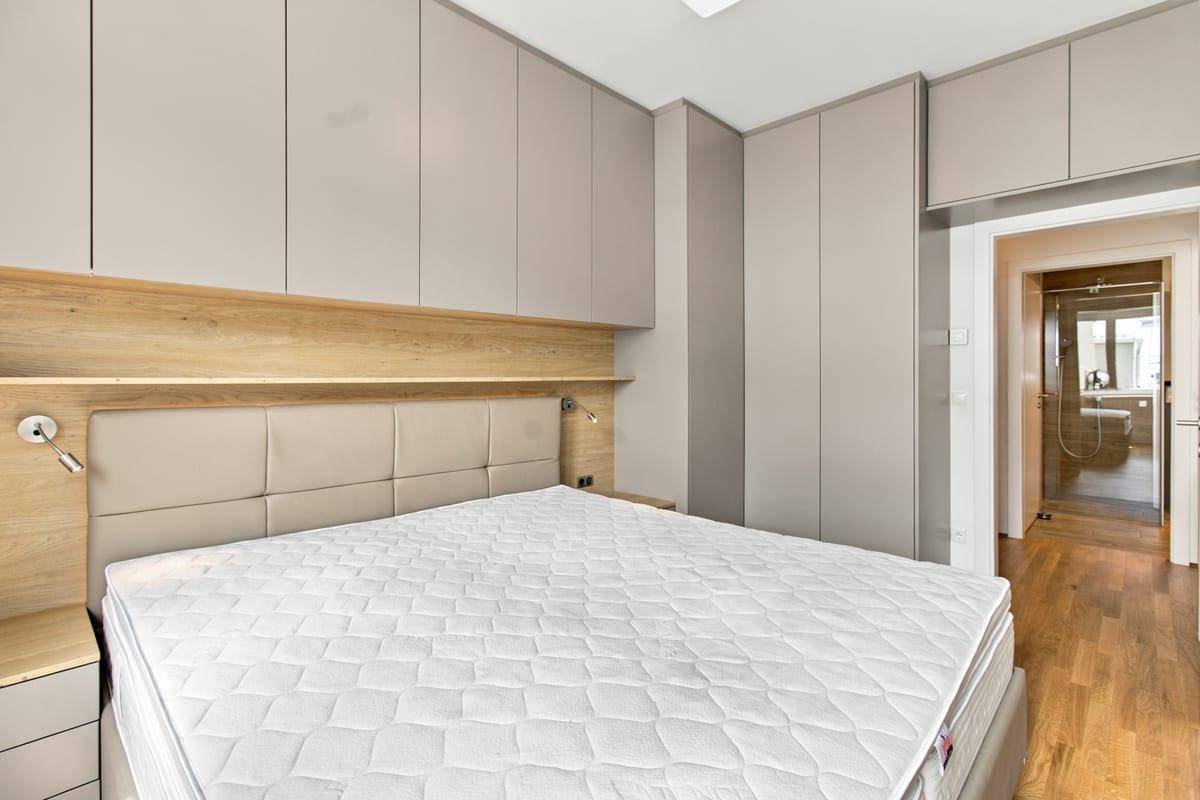 Modernes Schlafzimmer mit Einbauschränken, Holzelementen und Doppelbett.