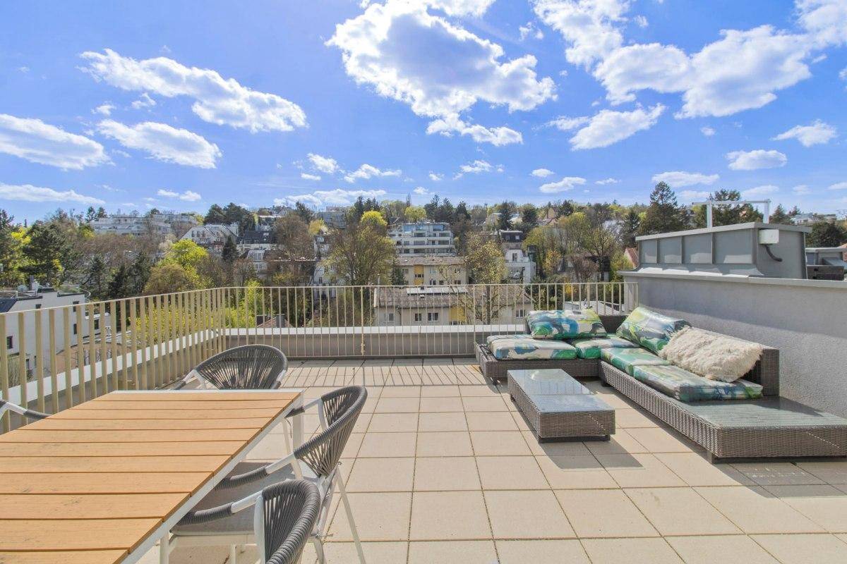 Weitläufige Dachterrasse mit Lounge-Bereich und Panoramablick über die Landschaft.