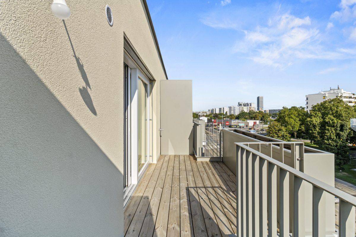 Balkon mit Holzbelag und Metallgeländer, bietet einen weiten Blick über die Stadt.