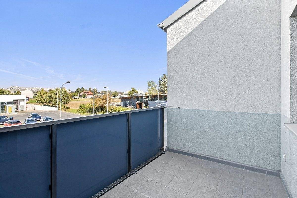 Geräumiger Balkon mit Fliesenboden und moderner Glasbrüstung, ideal für entspannte Stunden.